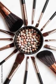 makeup brushes and powder forming a