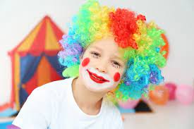 clown makeup in rainbow wig indoors