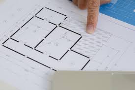 Architect Pointing To Building Plans