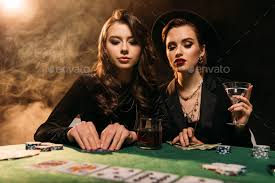attractive girls in black clothes playing poker at table in casino Stock  Photo by LightFieldStudios