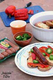 a plate of grilled smoked sausage and potatoes with toppings with a package of smoked sausages