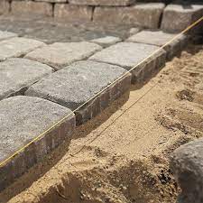 A mason's pointing trowel also helps to tamp wet stone dust into the joints. How To Design And Build A Paver Patio