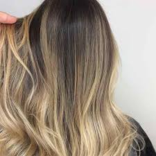 Dark brown hair having wavy layers styled with a dash of blonde highlight in the center for a bohemian style. The Foolproof Way To Go From Brown Hair To Blonde Hair Dale James Co Hair And Beauty Salon Perth