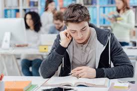 Find images of student desk. College Student Sitting At Desk And Studying A Book Group Of Stock Photo Picture And Royalty Free Image Image 96223804