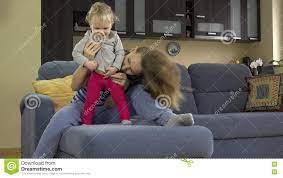 Красивое щекотание женщины Toddle живот ребенка сидя на софе сток-видео -  Видео насчитывающей обнимать, мама: 72635443