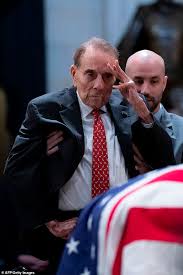 The former senate majority leader was badly wounded in the war, losing the ability to freely move his right hand and arm. Hero Salutes Hero Bob Dole Is Helped Out Of His Wheelchair So He Could Stand In Tribute To Bush Daily Mail Online