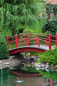 Lush Green Park Red Bridge Over A Pond