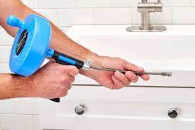 using a handheld auger to unclog a sink