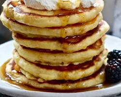 Gambar Pancakes served with butter, syrup, fruit, and whipped cream