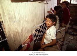 young children weaving carpets for up