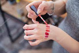 woman makeup artist testing lip gloss