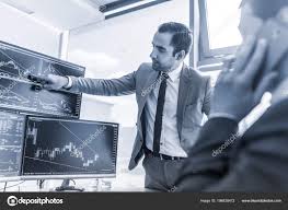 Stock Brokers Trading Online In Corporate Office Stock Photo