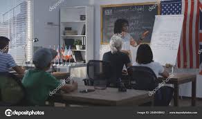Teacher Using Flip Chart While Explaining To A Class Stock