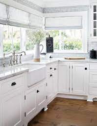 The backsplash made of white wood and white kitchen cabinets looks gorgeous with a dark wood floor and black hardware. 15 Popular Hardware Styles For Kitchens With Shaker Cabinets