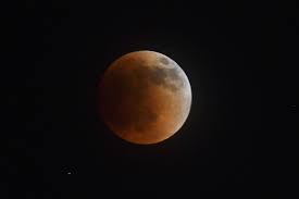 A blood moon lunar eclipse lights up ...