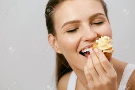食品。甘いデザートを食べる女性。クリームを手にカップケーキを持ち、お菓子を楽しむ美しいハッピー笑顔の女の子の肖像画。高品質 の写真素材・画像素材  Image 96944169.