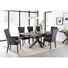 A small dining space with a wooden dining table paired with black chairs over concrete flooring. Vida Living Valerius Ceramic Metal Furniture Grey 170 220cm Extending Dining Table Oak Furniture House