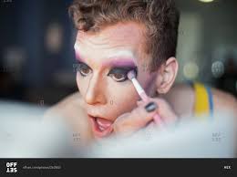 young man applying drag queen makeup