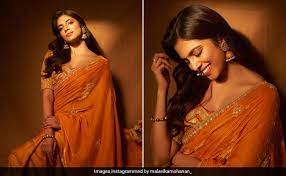 festive glow or her radiant orange saree