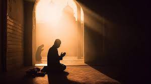 a man praying in a mosque with the sun