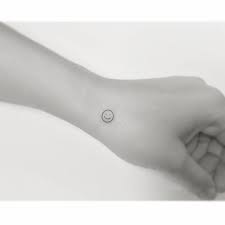 smiley face tattooed on the wrist