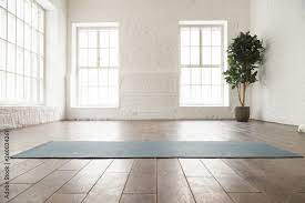unrolled yoga mat on wooden floor in