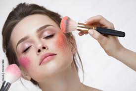 makeup applying blush stock photo