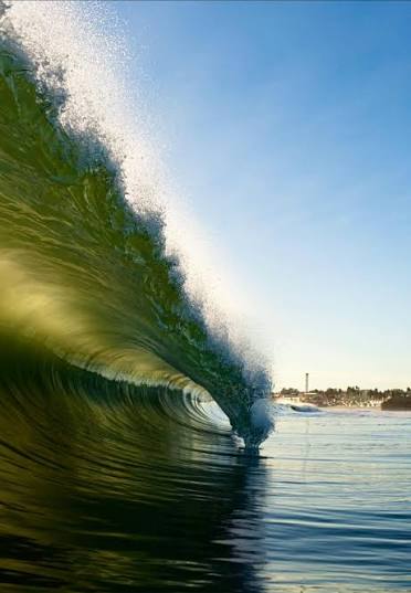 Glassy green waves breaking on the beach