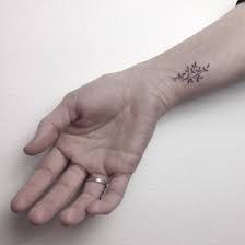 small flower tattoo on the right inner