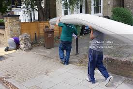 workmen carrying heavy carpet roll