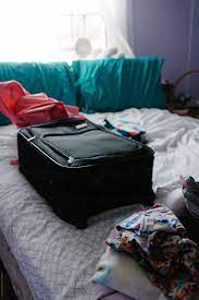 packed suitcase sitting on bed by