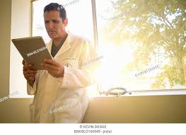 Hispanic Male Doctor Reading Chart Stock Photos And Images