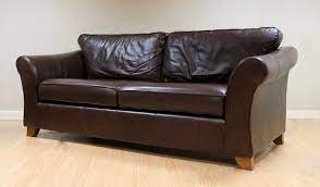 brown leather two seater sofa on wooden