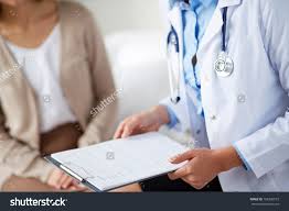 Stock Photo Female Doctor Holding Application Form While Consulting