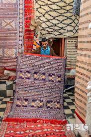 carpet dealer shows a moroccan carpet