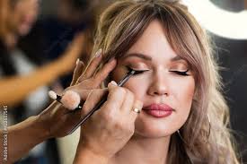 makeup artist applies eyeliner