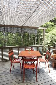 Quick and easy retractable awning. Diy Rock Weights For A Sun Shade Gardenista Deck Shade Outdoor Shade Pergola Plans Design