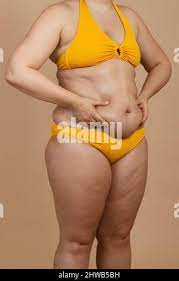 Körperpflege. Mollige Mädchen mit nackten Bauch stehend auf weiße Fett  schneiden mit Schere schließen isoliert - oben Stockfotografie - Alamy