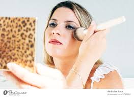 woman applying makeup at home a