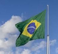 Bandeira brasileira tremulando no céu azul com nuvens ...