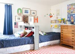 Fabulous shared boys' bedroom features twin beds on one shared headboard flanking a shared nightstand a peacock blue lamp under a light brown juju hat illuminated by swing arm wall sconces. Wonderful Boys Shared Bedroom Ideas 49 Design Secrets Download