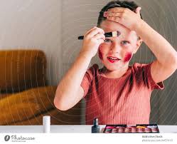 boy applying eyeshadow on face in house