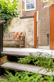 A Wooden Bench On A Patio With A Brick Wall