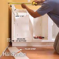 How to install base cabinets step 1 starting in a corner, mark a line along the wall where the top of the cabinet is going, using a spirit level to keep the line straight. How To Install Kitchen Cabinets Diy Family Handyman
