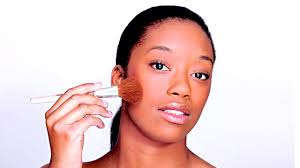 african woman applying makeup