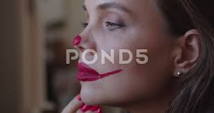 young woman paints clown makeup on her