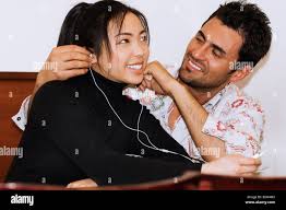 Joven muchacha asiática exótica y chico español italiano par escuchar  música besos Fotografía de stock - Alamy
