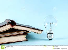 Books And Light Bulb On Blue Background Close Up Stock Image