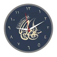 A Black And Gold Wall Clock With Arabic