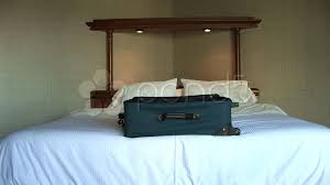 suitcase luge on bed in hotel room